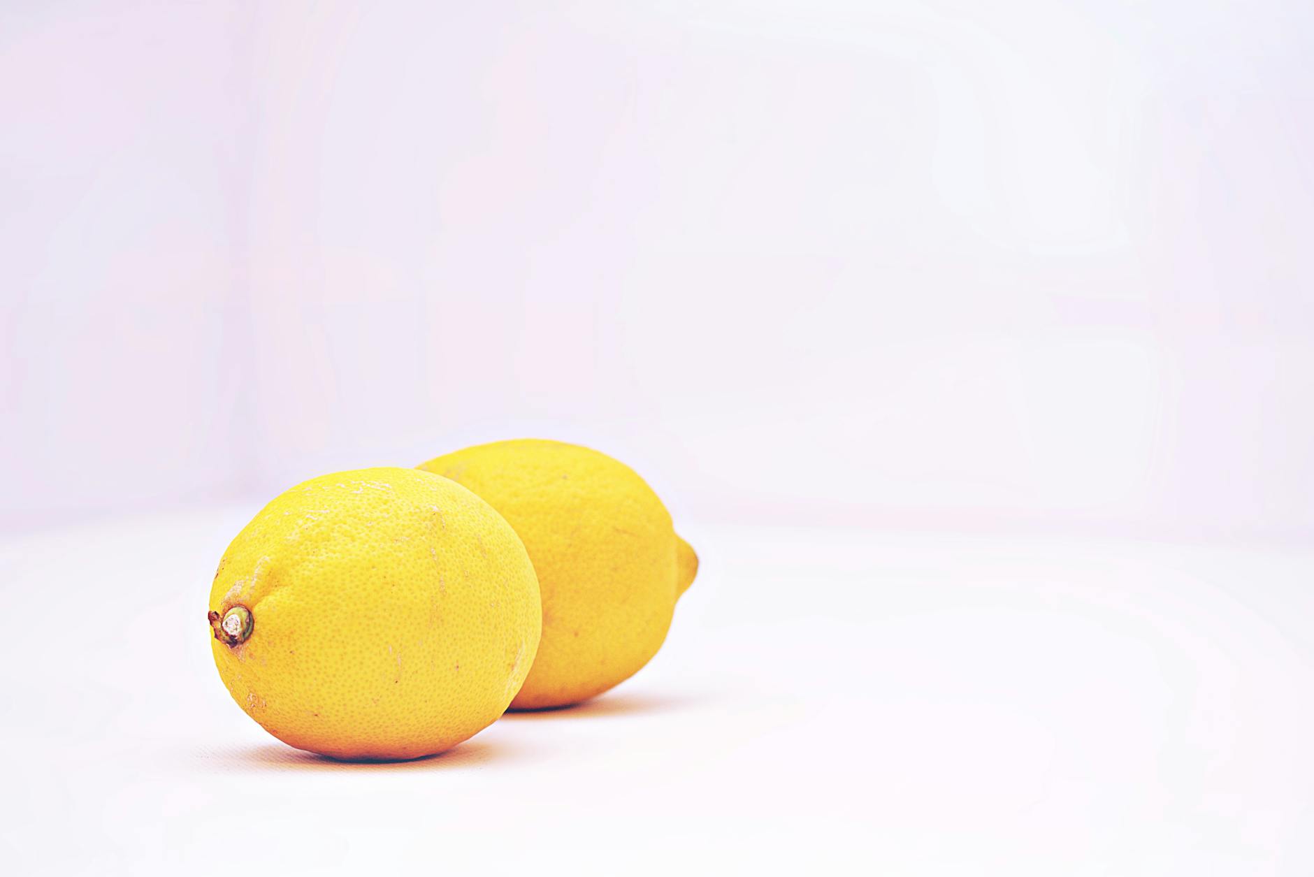 Two vibrant lemons on white background representing fresh approach to pleasure after 40