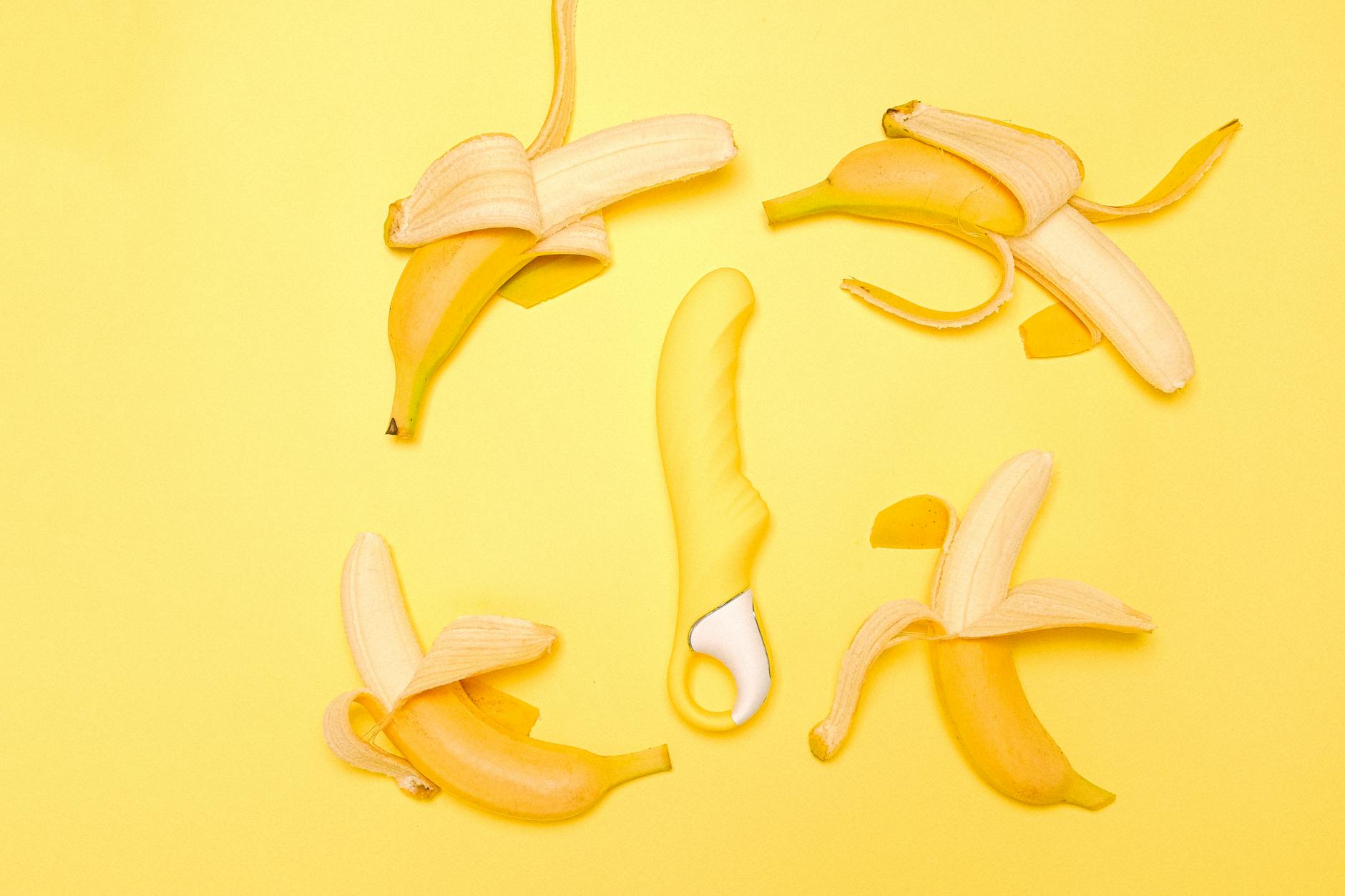 Yellow lemon vibrator surrounded by fresh lemons and citrus on bright background