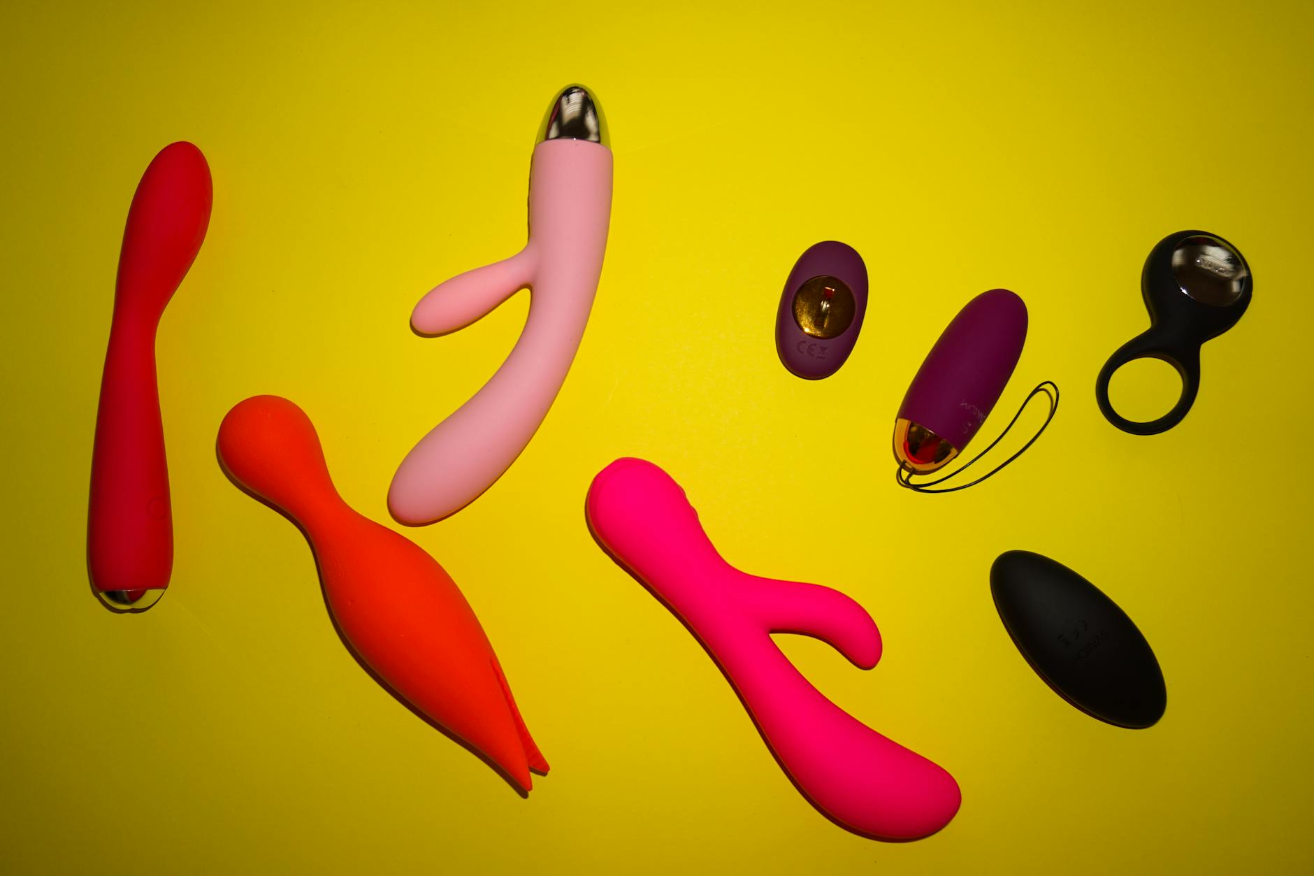 Close-up of hands holding a sleek lemon clitoral vibrator against a purple background