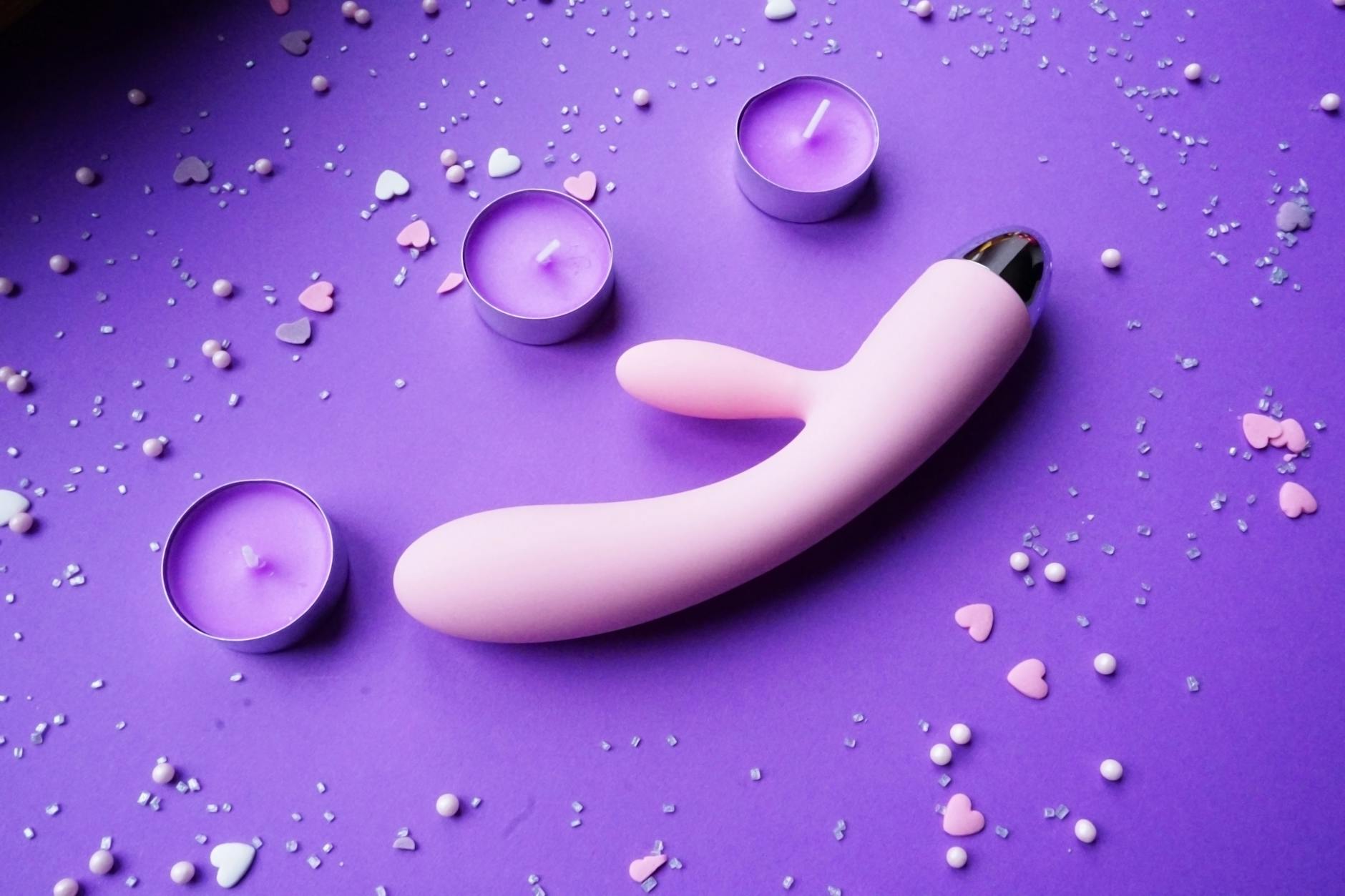 Colorful silicone clitoral vibrators on dark blue fabric, showcasing modern designs for intimate wellness.